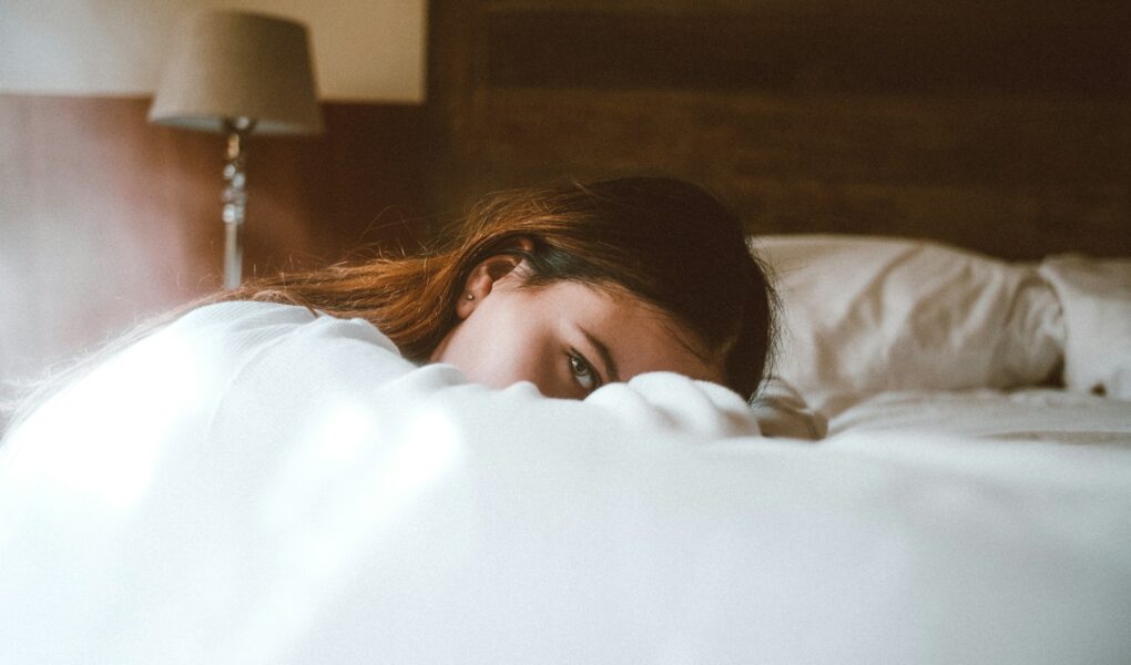 woman resting her head on bed