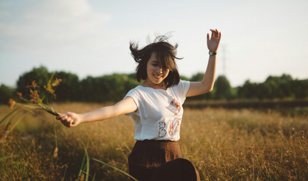 woman holding flower on field