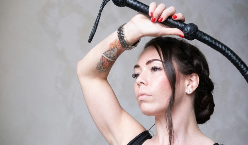 a woman with a tattoo on her arm holding a hair dryer