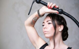 a woman with a tattoo on her arm holding a hair dryer